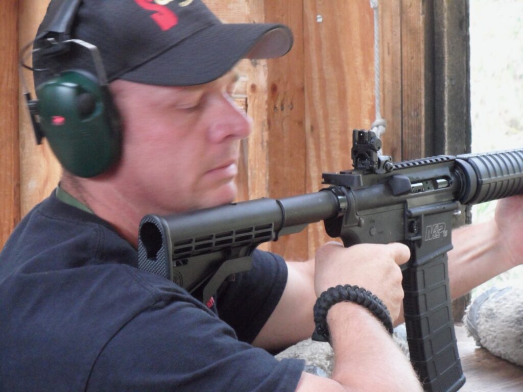 John Rader shouldering an AR-15 rifle at the range