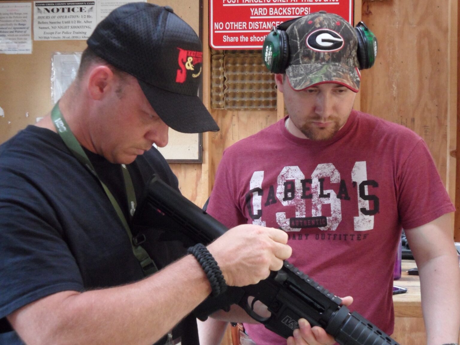 John Rader showing a student how to hold and load a shotgun at the range